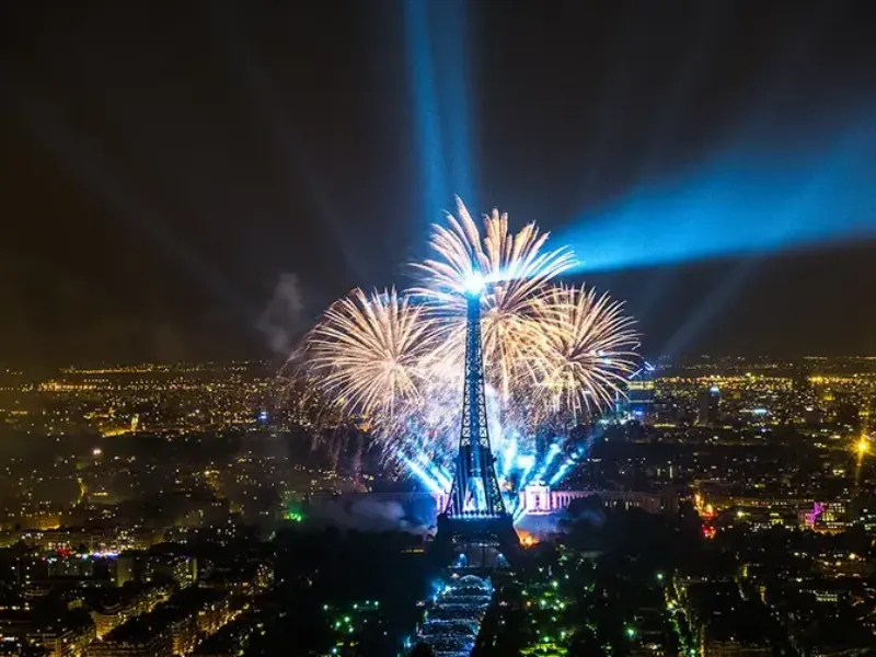 Feu d’artifice spectaculaire sur la Tour Eiffel à Paris le soir du 14 Juillet, illuminant le ciel parisien lors d’un jour de fete paris emblématique